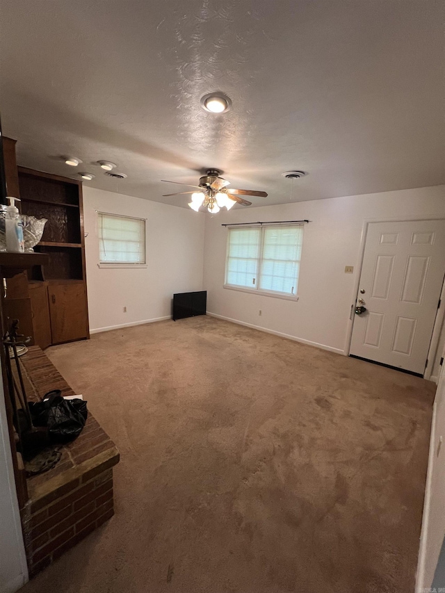 904 Belmont Dr, Pine Bluff, AR 71601 - unfurnished living room featuring carpet floors, built in features, baseboards, a ceiling fan, and a textured ceiling