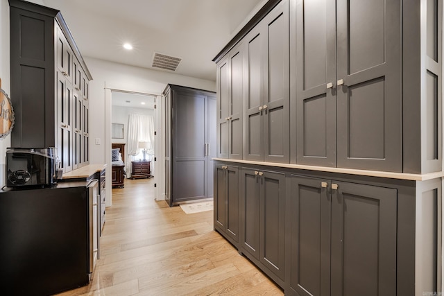 hall featuring visible vents, light wood-type flooring, and recessed lighting