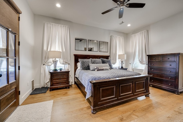 bedroom featuring visible vents, light wood-type flooring, and multiple windows