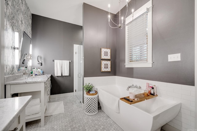 bathroom featuring a chandelier, vanity, a stall shower, a freestanding bath, and tile patterned flooring