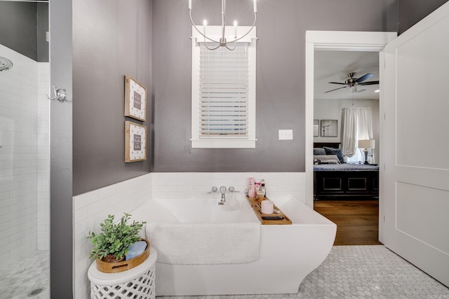 full bathroom with tile patterned floors, a tile shower, ensuite bathroom, a soaking tub, and ceiling fan with notable chandelier