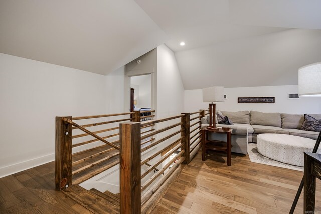 interior space featuring recessed lighting, lofted ceiling, visible vents, baseboards, and wood finished floors