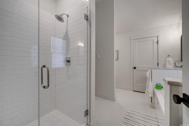 bathroom featuring tile patterned floors, a stall shower, and baseboards