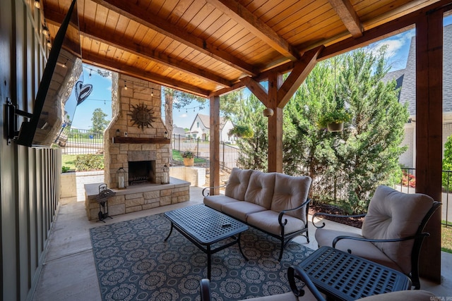 view of patio / terrace with an outdoor living space with a fireplace and fence