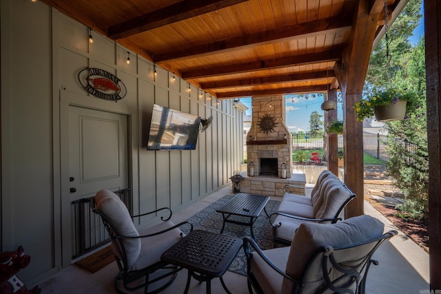 view of patio with an outdoor stone fireplace and fence