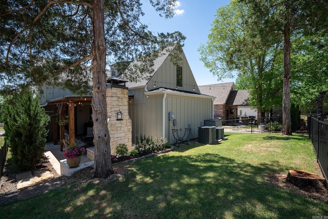 exterior space featuring a patio area, a yard, a fenced backyard, board and batten siding, and roof with shingles