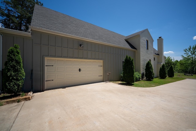 view of home's exterior with driveway, a garage, board and batten siding, and a shingled roof