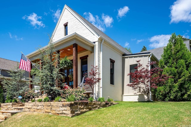 view of front of home featuring brick siding and a front yard