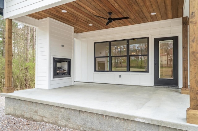 view of patio with a fireplace and ceiling fan
