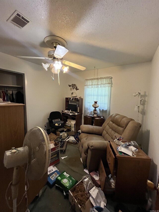 carpeted living area featuring visible vents, ceiling fan, and a textured ceiling