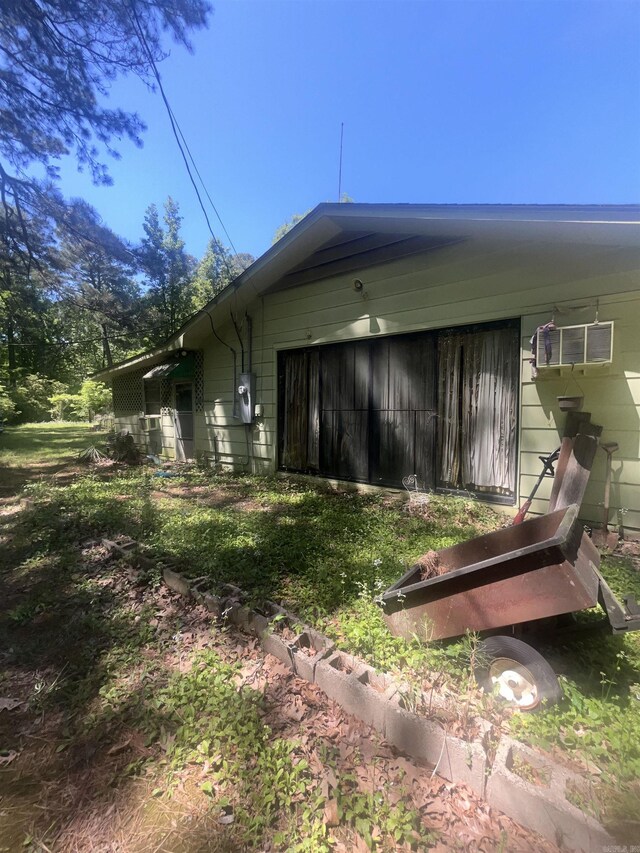 view of side of property featuring a wall mounted air conditioner and an attached garage