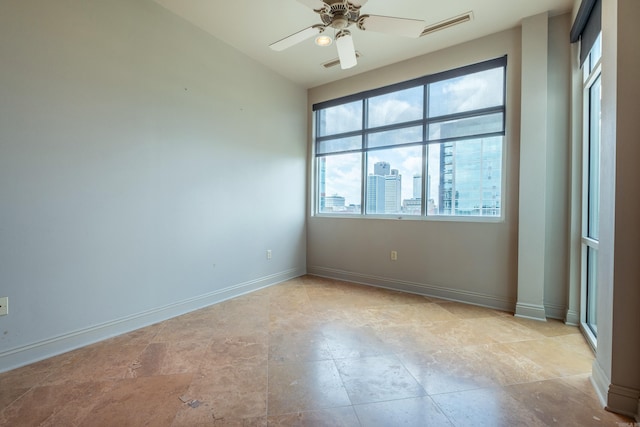 unfurnished room featuring ceiling fan, visible vents, and baseboards