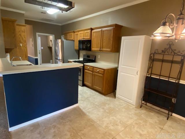 kitchen featuring a sink, a chandelier, brown cabinetry, crown molding, and appliances with stainless steel finishes