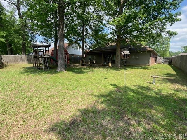view of yard with a fenced backyard and a playground