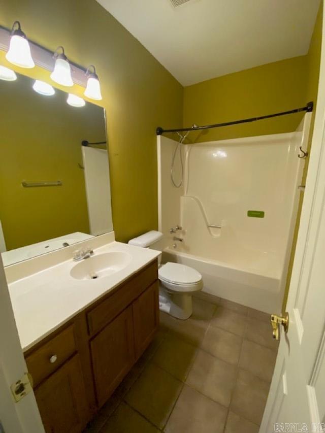 bathroom with tile patterned floors, toilet, vanity, visible vents, and tub / shower combination
