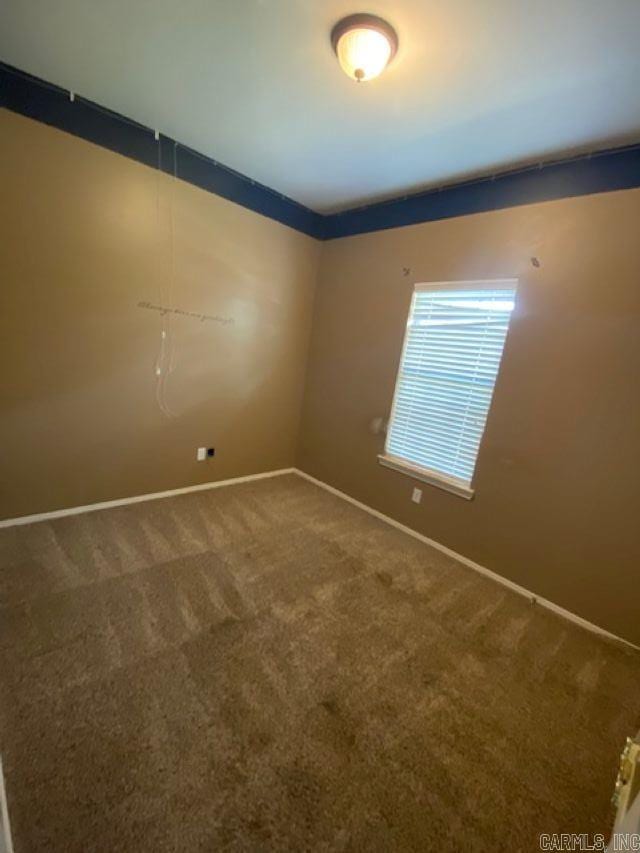 empty room featuring baseboards and carpet floors