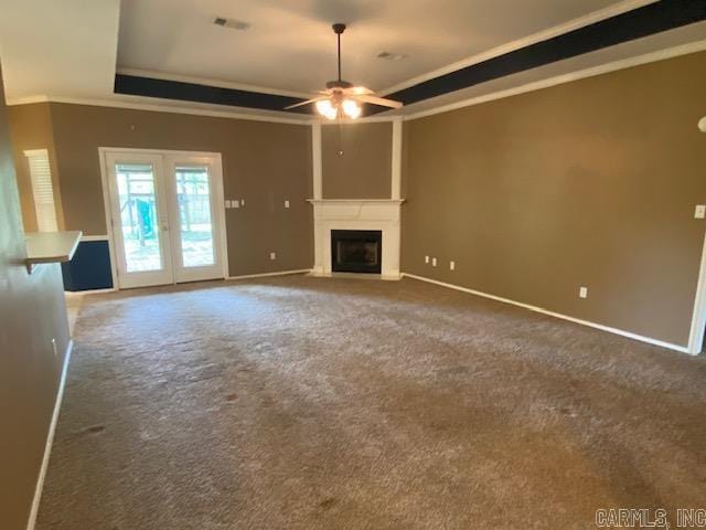 unfurnished living room featuring a tray ceiling, crown molding, a ceiling fan, visible vents, and baseboards