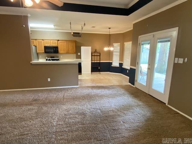 kitchen featuring crown molding, black microwave, light brown cabinetry, and carpet flooring