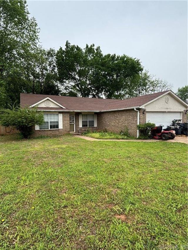ranch-style home with brick siding, a front lawn, concrete driveway, and an attached garage