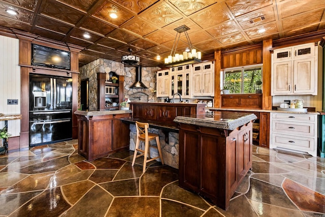 kitchen with glass insert cabinets, a spacious island, black refrigerator with ice dispenser, an ornate ceiling, and visible vents