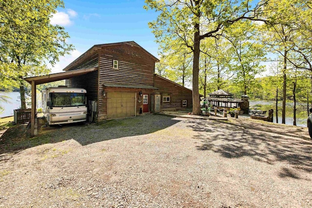 view of side of property featuring a carport and gravel driveway