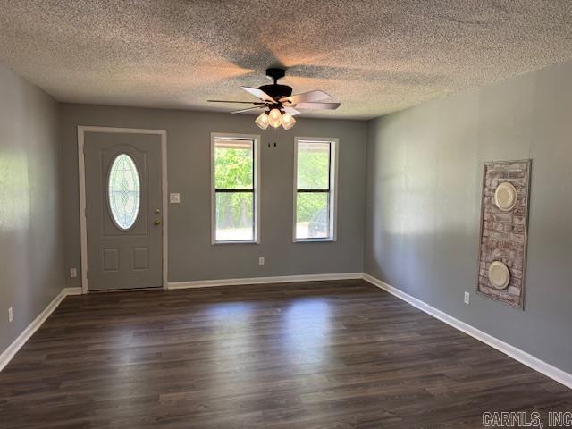 entrance foyer with dark wood finished floors, a ceiling fan, and a textured ceiling