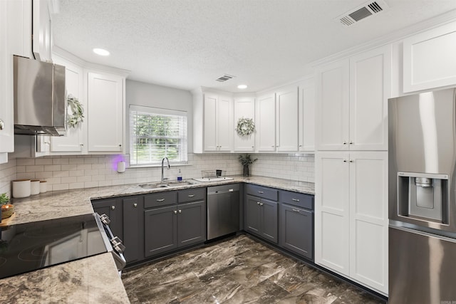 kitchen with white cabinets, appliances with stainless steel finishes, a sink, visible vents, and gray cabinetry