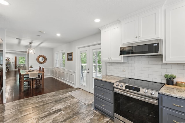 kitchen with decorative backsplash, light stone countertops, gray cabinetry, stainless steel appliances, and white cabinetry