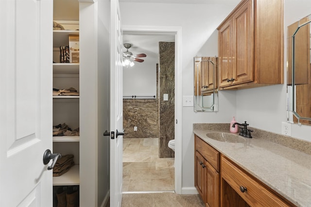 bathroom featuring toilet, ceiling fan, and vanity