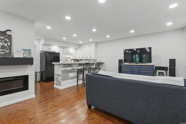 living room with recessed lighting and dark wood finished floors