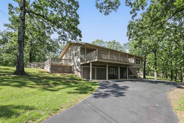 view of front of house with a front lawn, a garage, a deck, stairway, and driveway