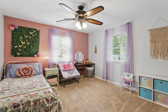 bedroom featuring a ceiling fan, carpet flooring, and a textured ceiling