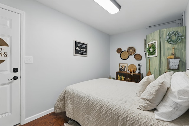 bedroom featuring baseboards and dark wood-style floors