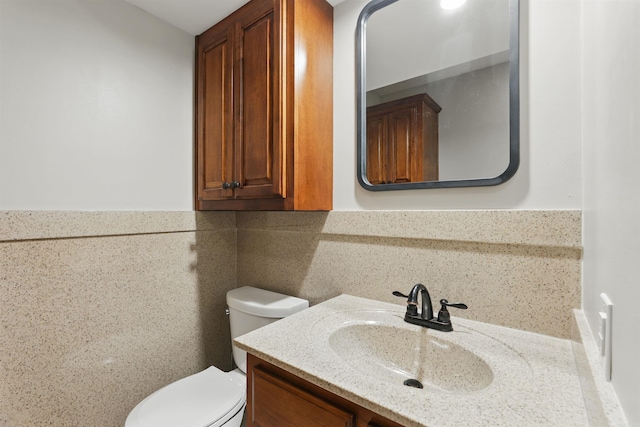 half bathroom featuring vanity and toilet