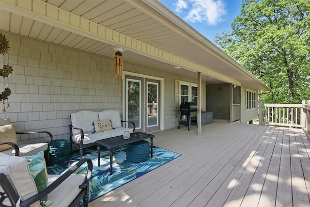 wooden terrace with an outdoor hangout area and grilling area