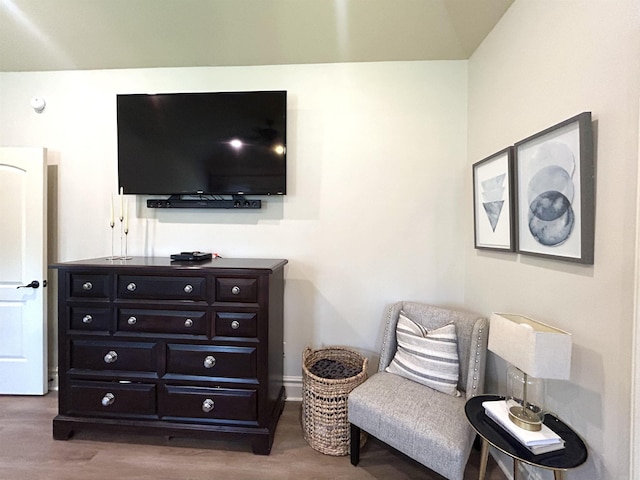 living area with baseboards and wood finished floors