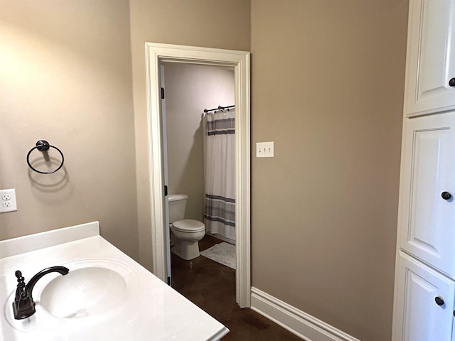 bathroom with baseboards, a shower with shower curtain, toilet, and vanity