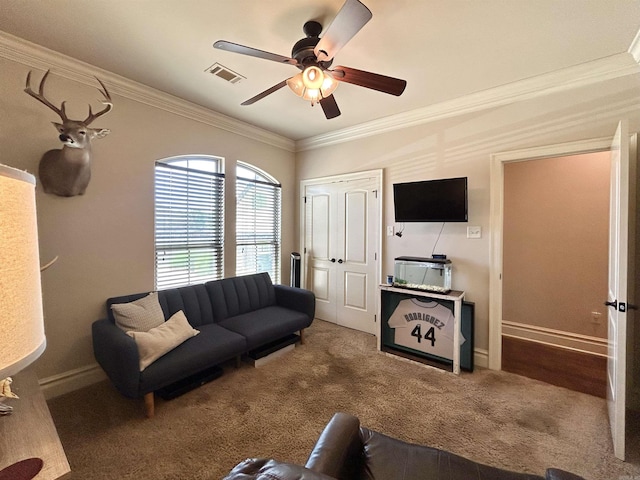 carpeted living room with baseboards, ornamental molding, ceiling fan, and visible vents