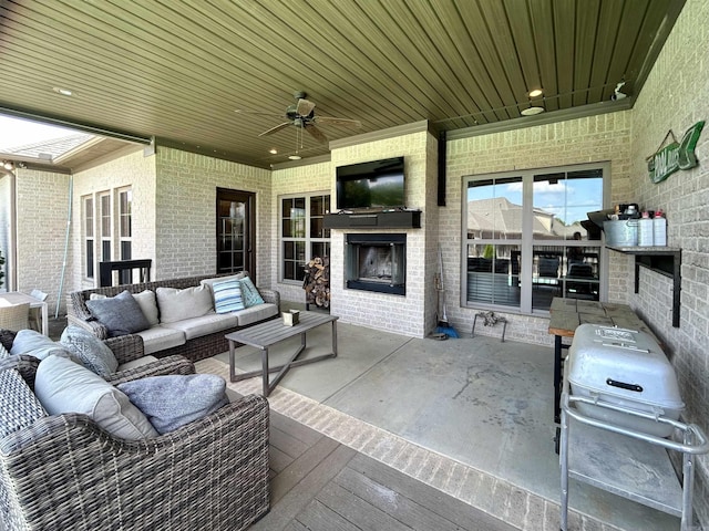 view of patio / terrace with grilling area, a ceiling fan, and an outdoor living space with a fireplace