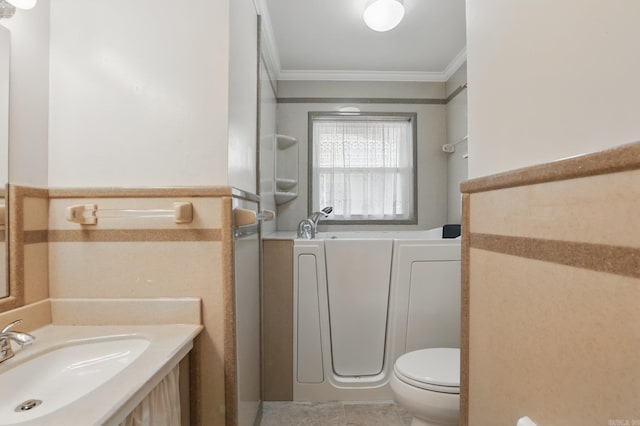full bathroom with ornamental molding, a wainscoted wall, toilet, a bathtub, and vanity