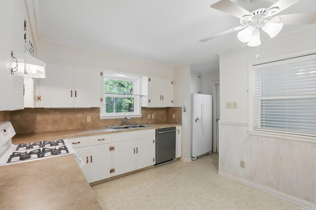 kitchen with decorative backsplash, a sink, light countertops, under cabinet range hood, and white appliances