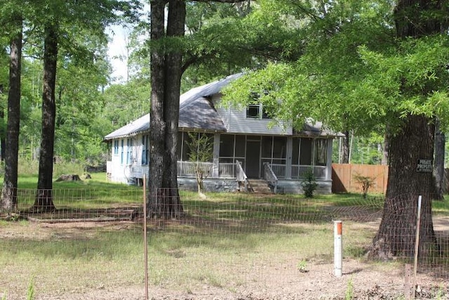 view of front of property featuring fence private yard and a sunroom