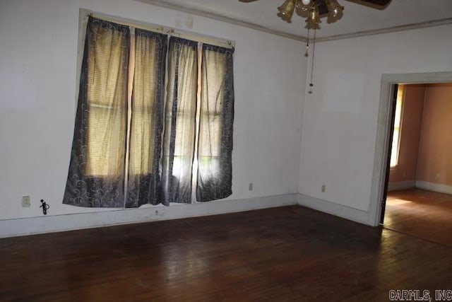 spare room featuring baseboards, wood finished floors, ceiling fan, and ornamental molding