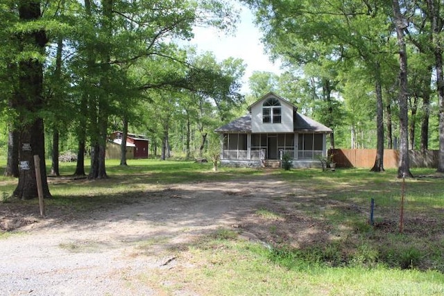 view of front of home featuring fence and a sunroom