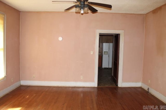 spare room featuring a ceiling fan, wood finished floors, and baseboards