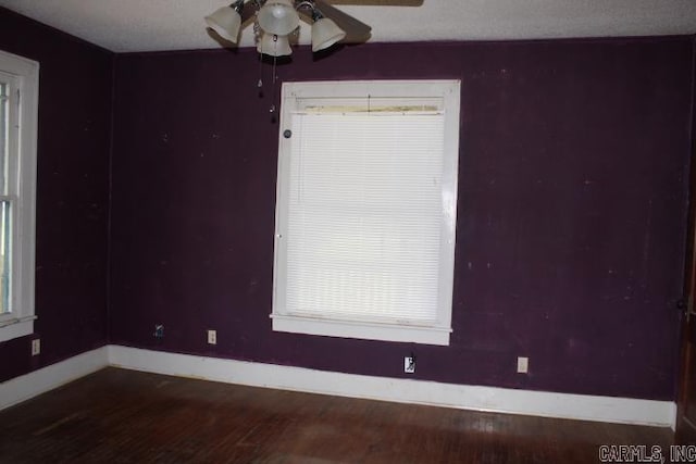 unfurnished room with baseboards, wood finished floors, and ceiling fan