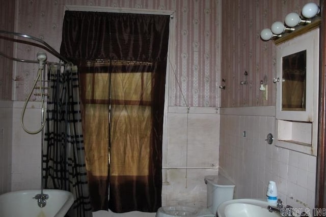 bathroom with tile walls and a freestanding tub