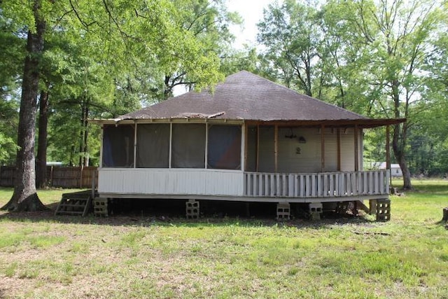exterior space with a front yard, fence, a sunroom, and roof with shingles