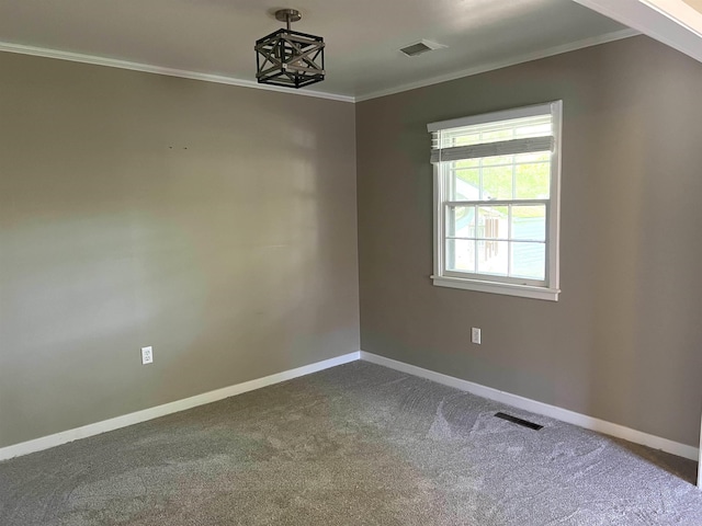 unfurnished room with dark colored carpet, visible vents, crown molding, and baseboards