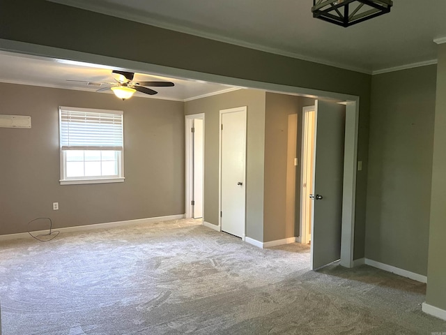 carpeted spare room with baseboards, visible vents, ornamental molding, and a ceiling fan